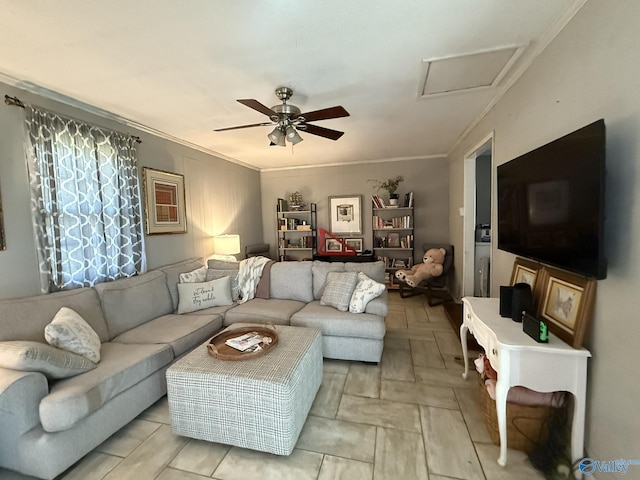 living area with attic access, ornamental molding, and ceiling fan