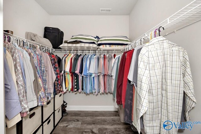 spacious closet featuring dark wood-style flooring and visible vents