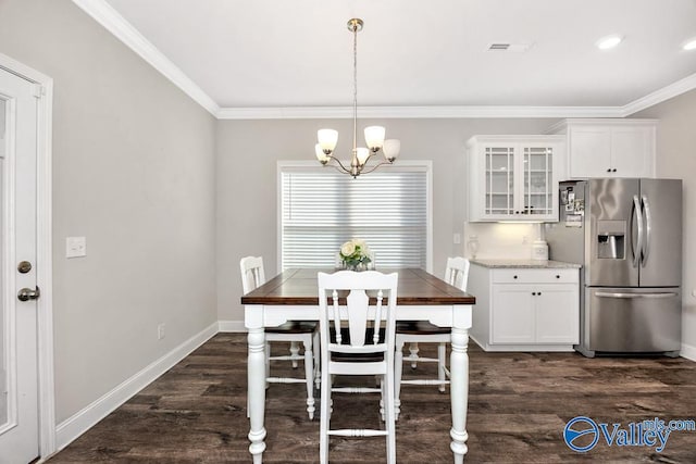 dining room featuring baseboards, dark wood-type flooring, visible vents, and crown molding