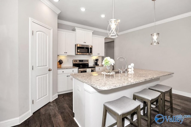 kitchen featuring white cabinets, stainless steel appliances, a kitchen island with sink, and pendant lighting