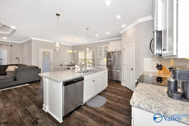 kitchen featuring stainless steel appliances, a kitchen island with sink, hanging light fixtures, and white cabinetry