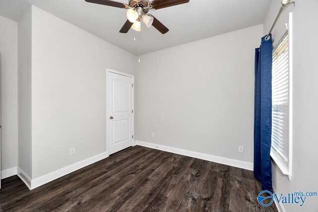 unfurnished bedroom featuring ceiling fan, baseboards, and dark wood-style flooring