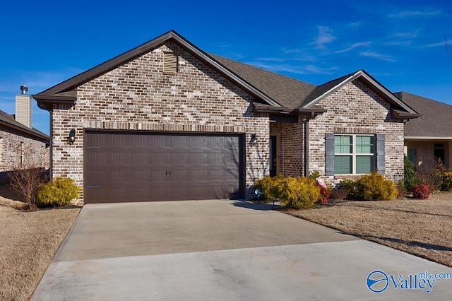 view of front of home featuring an attached garage, driveway, a shingled roof, and brick siding