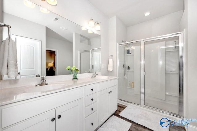 full bath featuring double vanity, a stall shower, visible vents, and a sink