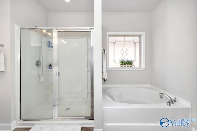 bathroom featuring a stall shower and a garden tub