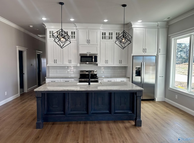 kitchen featuring light stone counters, appliances with stainless steel finishes, decorative light fixtures, and white cabinets