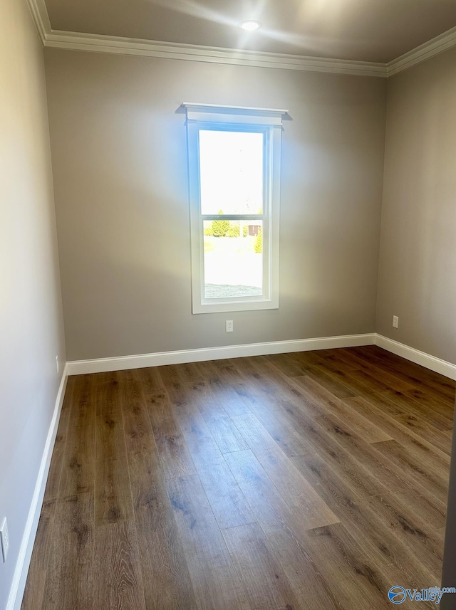 empty room with crown molding and dark hardwood / wood-style flooring