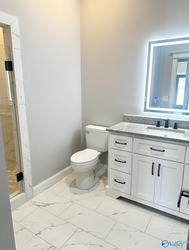 bathroom featuring vanity, a shower with door, and toilet