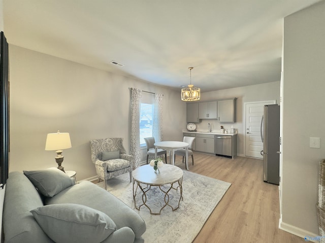 211 Shangrila Way, Meridianville, AL 35759 - living room featuring light wood-style flooring, baseboards, and a chandelier