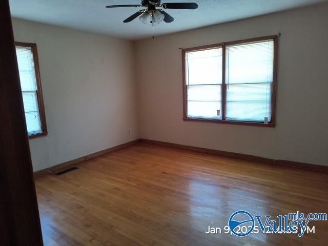 spare room with ceiling fan and wood-type flooring