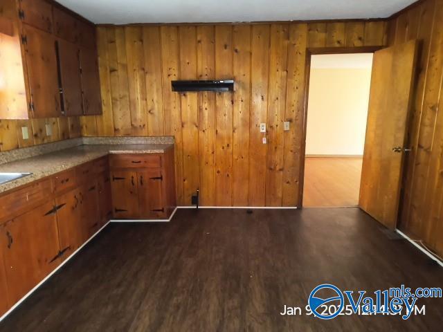 kitchen featuring dark hardwood / wood-style floors and wood walls