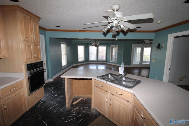 kitchen featuring a textured ceiling, crown molding, sink, a notable chandelier, and oven