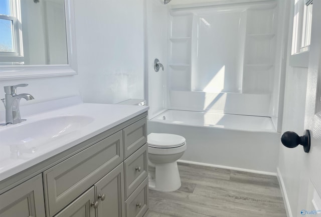 bathroom with shower / tub combination, toilet, wood finished floors, vanity, and baseboards