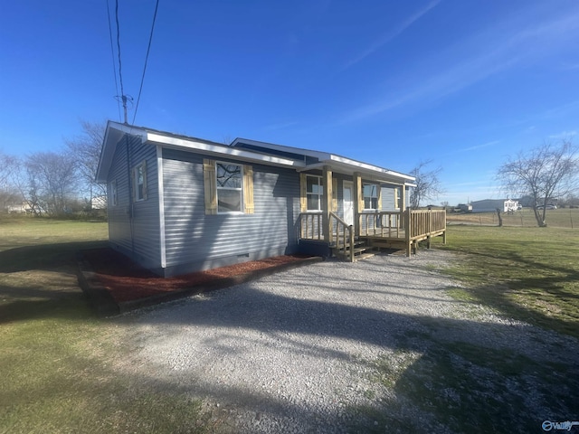 view of front of home featuring gravel driveway, a front yard, and crawl space