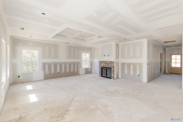 unfurnished living room featuring coffered ceiling and a fireplace