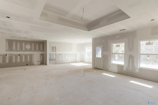 unfurnished living room with a raised ceiling