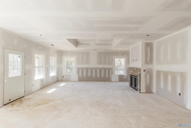 unfurnished living room with a brick fireplace and a wealth of natural light