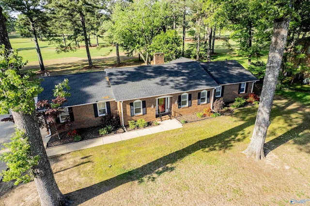 ranch-style house with brick siding, a front lawn, a chimney, and a shingled roof