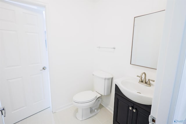bathroom with baseboards, vanity, toilet, and tile patterned flooring