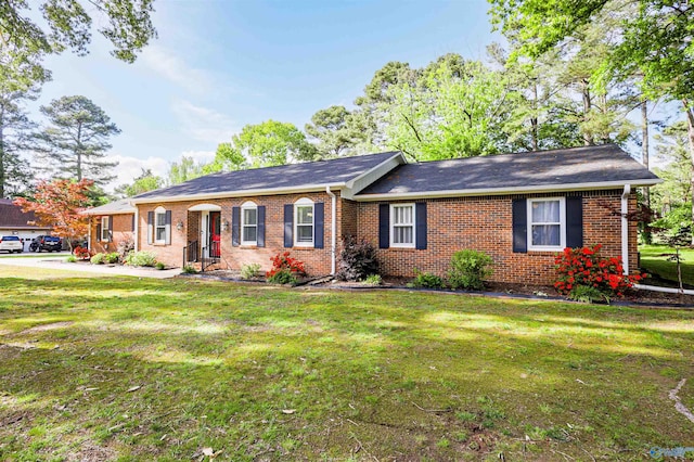 single story home featuring brick siding and a front yard