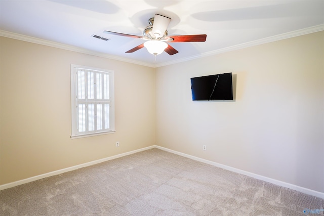 carpeted spare room with ornamental molding, ceiling fan, and baseboards