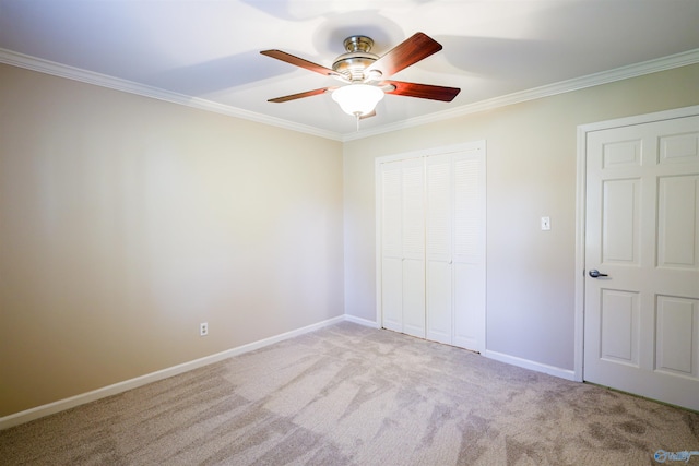 unfurnished bedroom with ornamental molding, carpet floors, a closet, baseboards, and ceiling fan