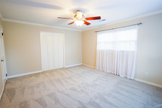 unfurnished bedroom featuring ornamental molding, carpet flooring, a closet, and baseboards