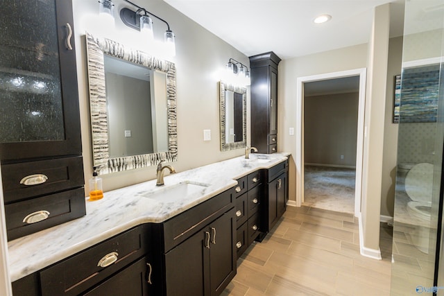 bathroom featuring double vanity, baseboards, and wood tiled floors