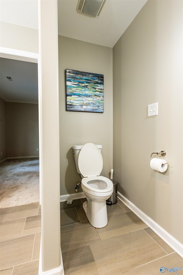 bathroom featuring baseboards and toilet