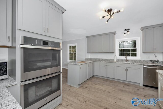 2512 Vista Dr SE, Huntsville, AL 35803 - kitchen with stainless steel appliances, a sink, gray cabinetry, light wood-style floors, and light stone counters