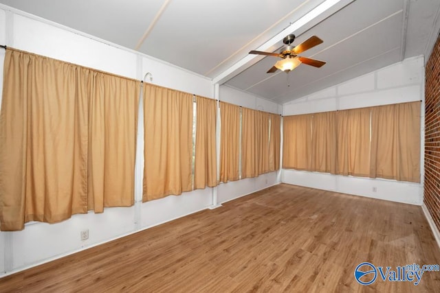 empty room featuring vaulted ceiling, hardwood / wood-style flooring, and ceiling fan