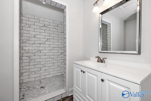 bathroom with vanity and a tile shower