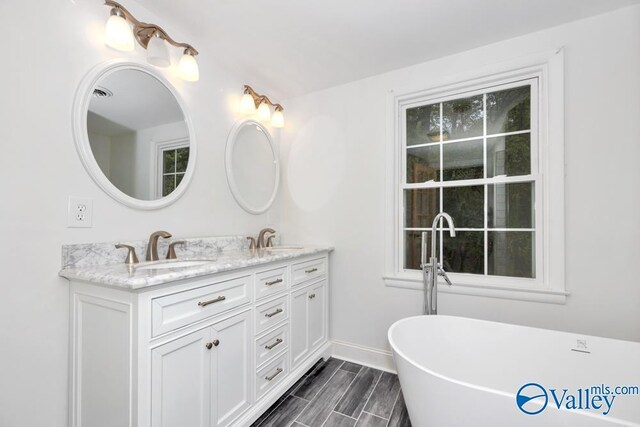 2512 Vista Dr SE, Huntsville, AL 35803 - full bath with double vanity, a freestanding tub, and baseboards
