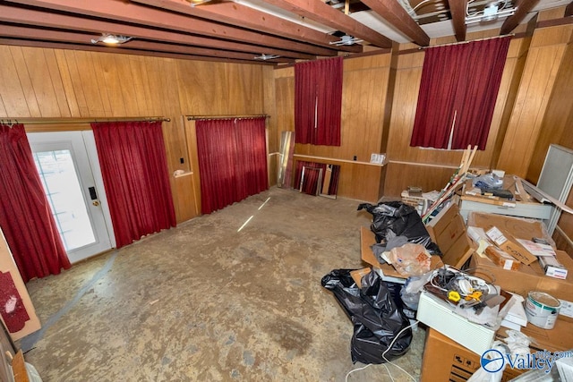 misc room featuring concrete flooring and wooden walls