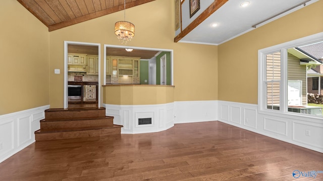 919 Colquitt Rd, Gadsden, AL 35903 - empty room featuring wood finished floors, a chandelier, lofted ceiling, stairway, and wainscoting