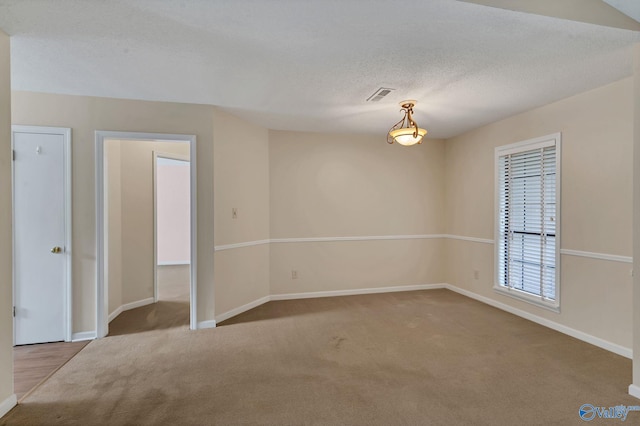 spare room featuring carpet and a textured ceiling