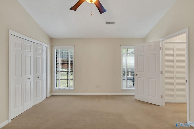 unfurnished bedroom with ceiling fan, lofted ceiling, and multiple windows