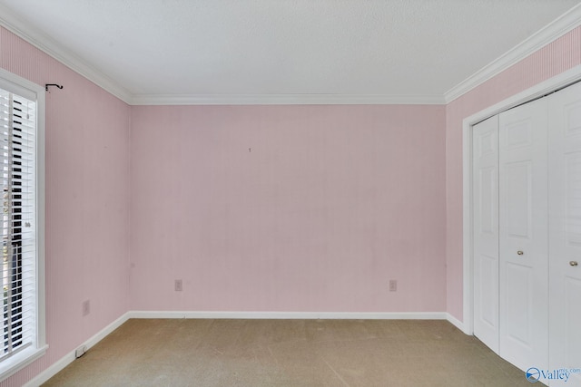 unfurnished bedroom featuring a textured ceiling, carpet floors, ornamental molding, and a closet