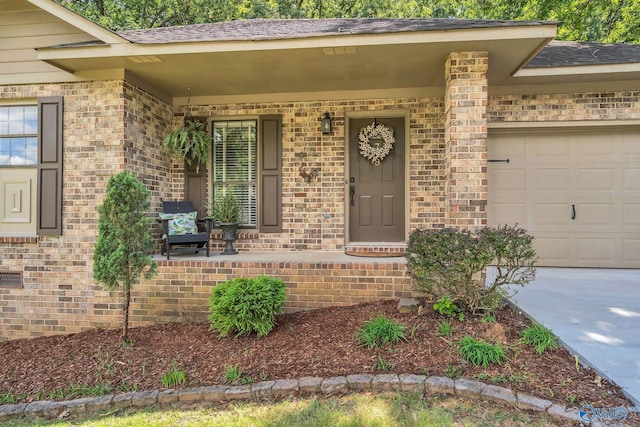 view of exterior entry with covered porch and a garage