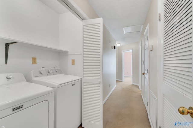 washroom with washer and clothes dryer and light carpet