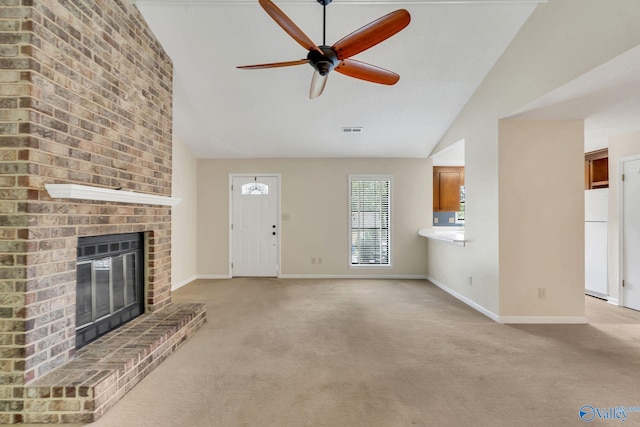 unfurnished living room with ceiling fan, a fireplace, light carpet, and vaulted ceiling