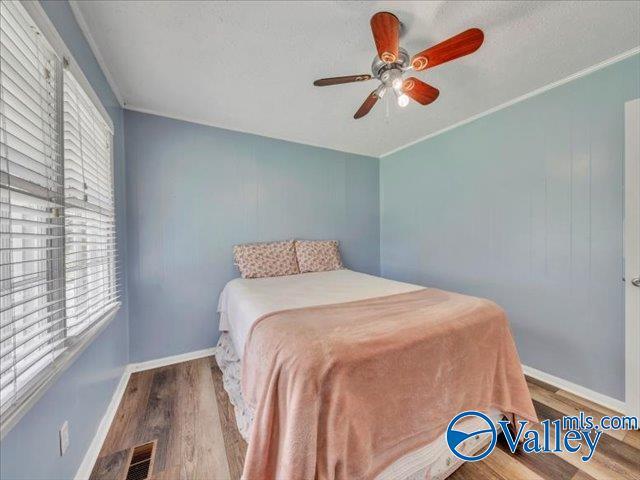 bedroom featuring wood finished floors, baseboards, and ceiling fan
