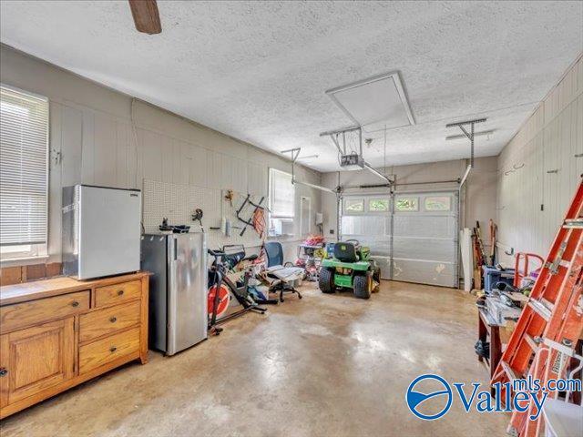 garage with freestanding refrigerator and a garage door opener