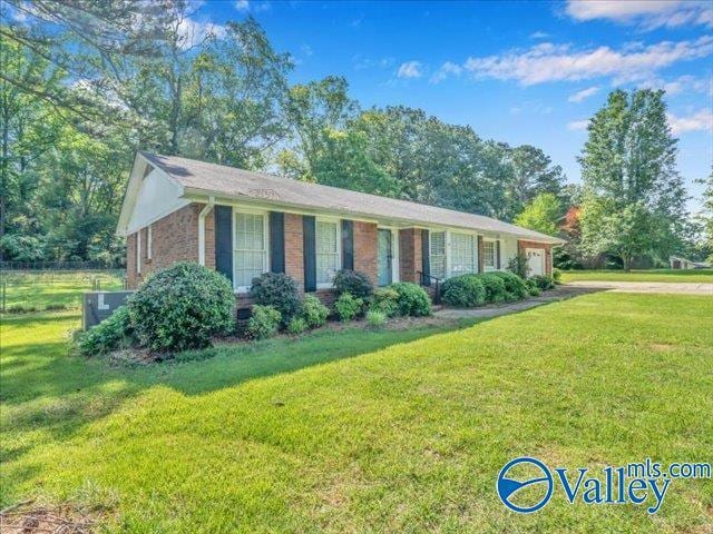 ranch-style house with a garage, a front yard, driveway, and brick siding