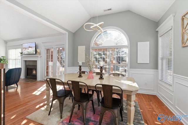 dining room featuring an inviting chandelier, hardwood / wood-style flooring, and lofted ceiling