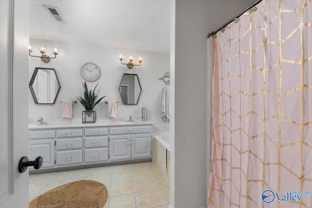 bathroom featuring vanity, curtained shower, tile patterned floors, and a textured ceiling