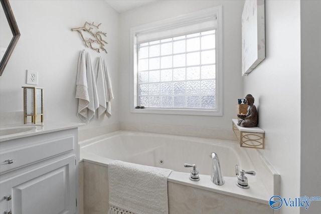 bathroom featuring vanity and tiled bath