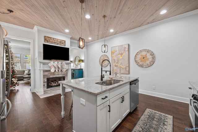 kitchen featuring pendant lighting, an island with sink, dishwasher, sink, and light stone counters