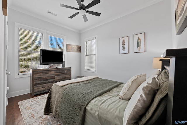 bedroom with dark hardwood / wood-style flooring, ornamental molding, and ceiling fan