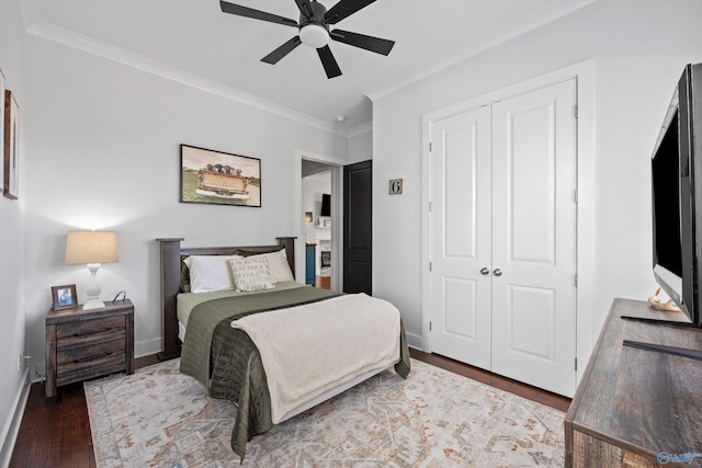 bedroom with ornamental molding, dark hardwood / wood-style floors, ceiling fan, and a closet